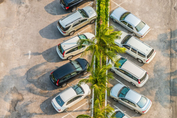 Un plan drone d'un parking automobile avec des palmiers au centre